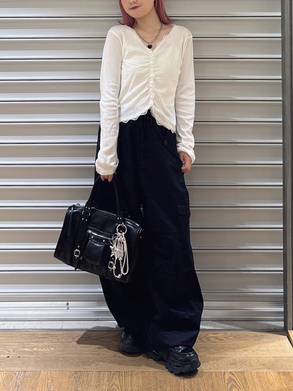 ブラック系のカーゴパンツ、ホワイト系のカーディガン/ボレロ、ブラック系のローファーを着用したレディースの夏コーディネートの2枚目の写真
