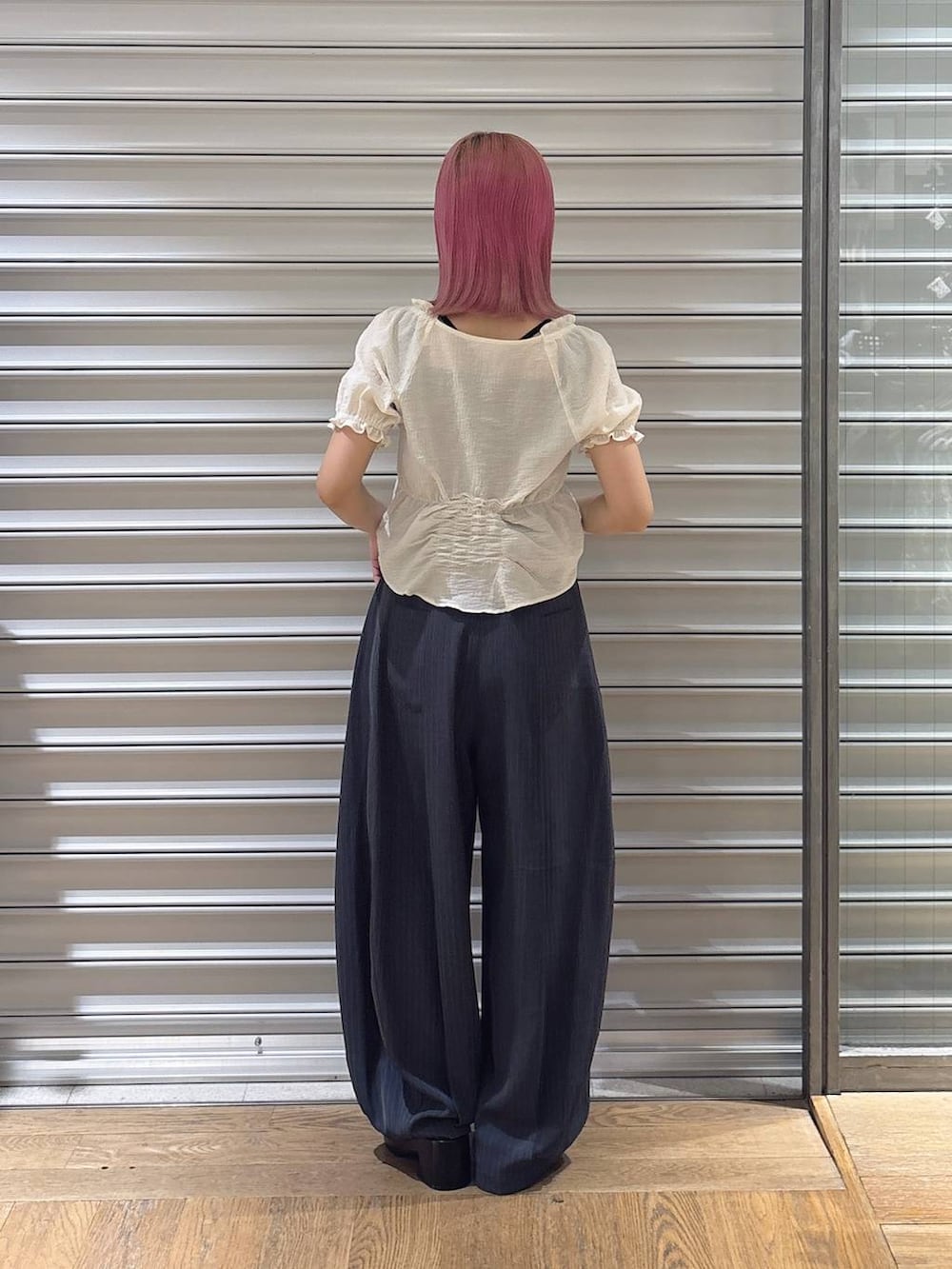 ホワイト系のシャツ/ブラウス、ブラック系のタンクトップ、グレー系のスラックスを着用したレディースの夏コーディネートの3枚目の写真
