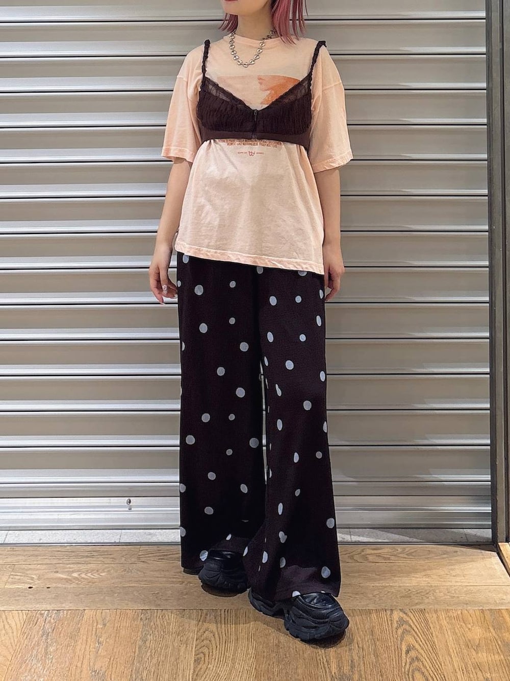 ブラウン系のその他パンツ、ブラウン系のキャミソール、オレンジ系のTシャツ/カットソーを着用したレディースの夏コーディネートの2枚目の写真