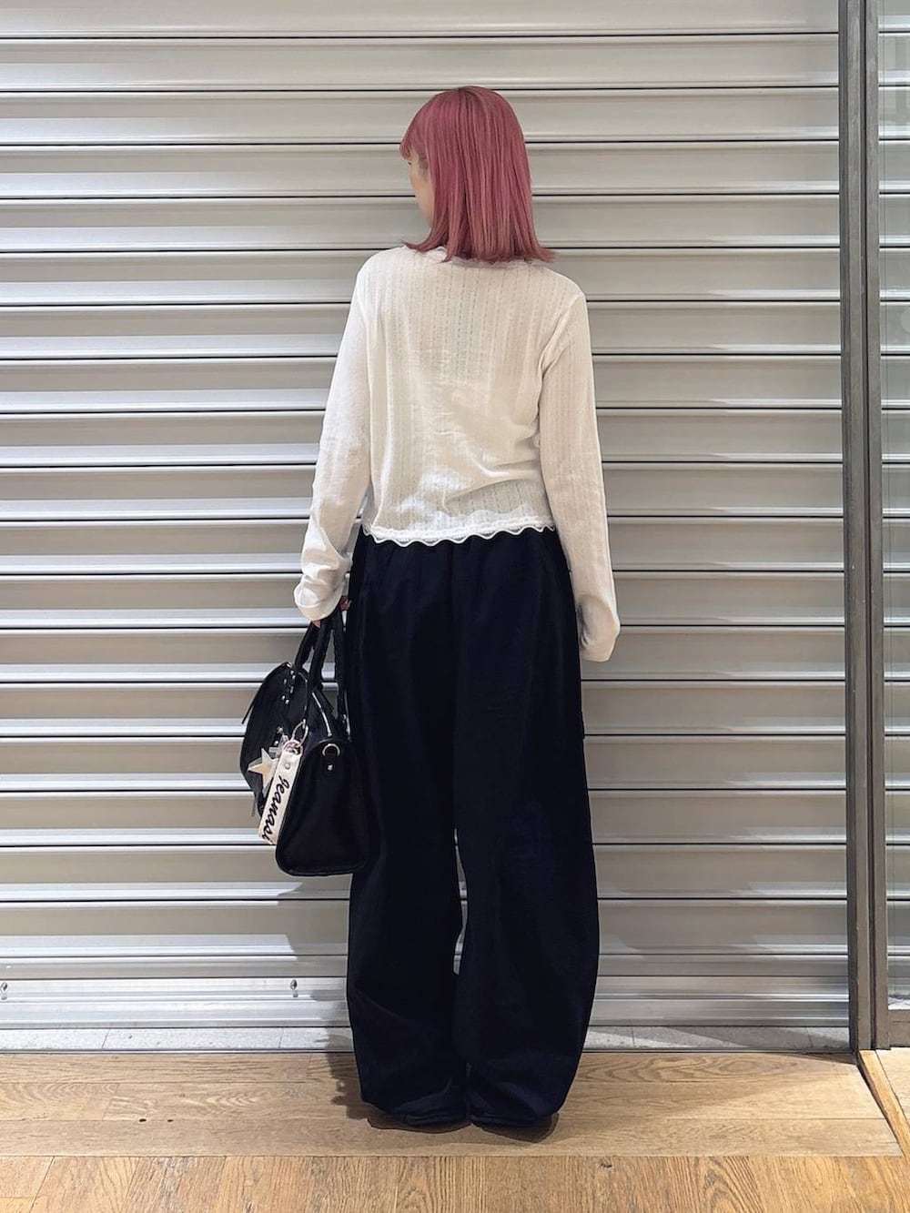 ブラック系のカーゴパンツ、ホワイト系のカーディガン/ボレロ、ブラック系のローファーを着用したレディースの夏コーディネートの3枚目の写真