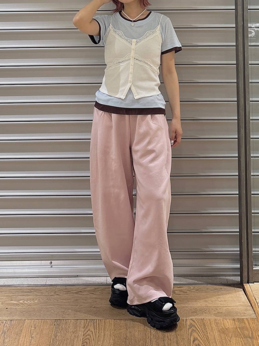 ピンク系のスウェットパンツ、ブラック系のサンダル、ホワイト系のキャミソールを着用したレディースの春コーディネートの2枚目の写真