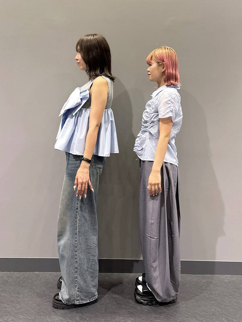 ブルー系のデニムパンツ、ブラック系のサンダル、グレー系のスラックスを着用したレディースの春コーディネートの4枚目の写真