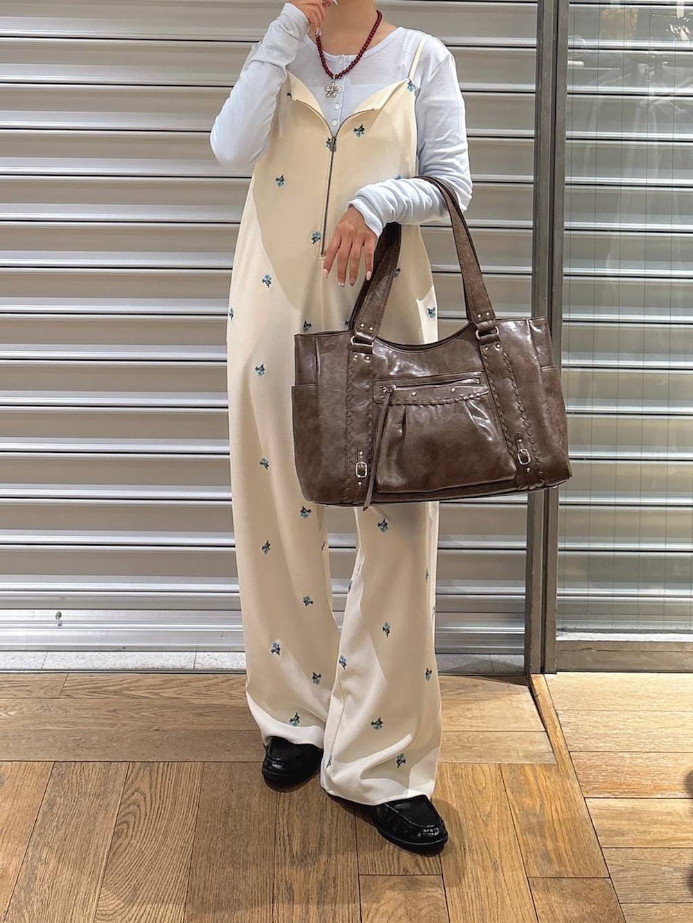 ホワイト系のサロペット/オーバーオール、ブラウン系のトートバッグ、ブラック系のローファーを着用したレディースの冬コーディネートの2枚目の写真