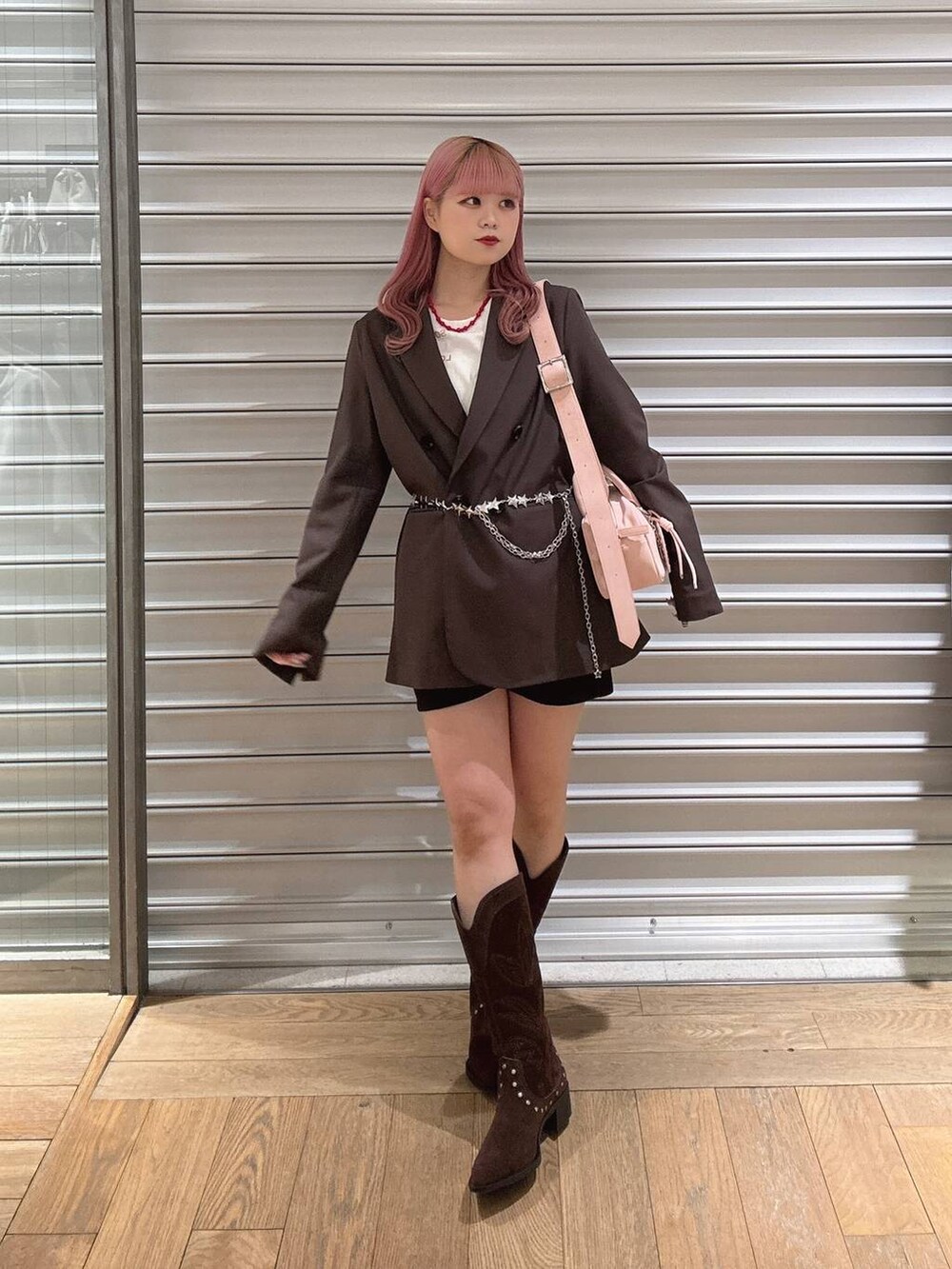 ブラウン系のテーラードジャケット、ピンク系のボストンバッグ、ブラウン系のブーツを着用したレディースの冬コーディネートの2枚目の写真