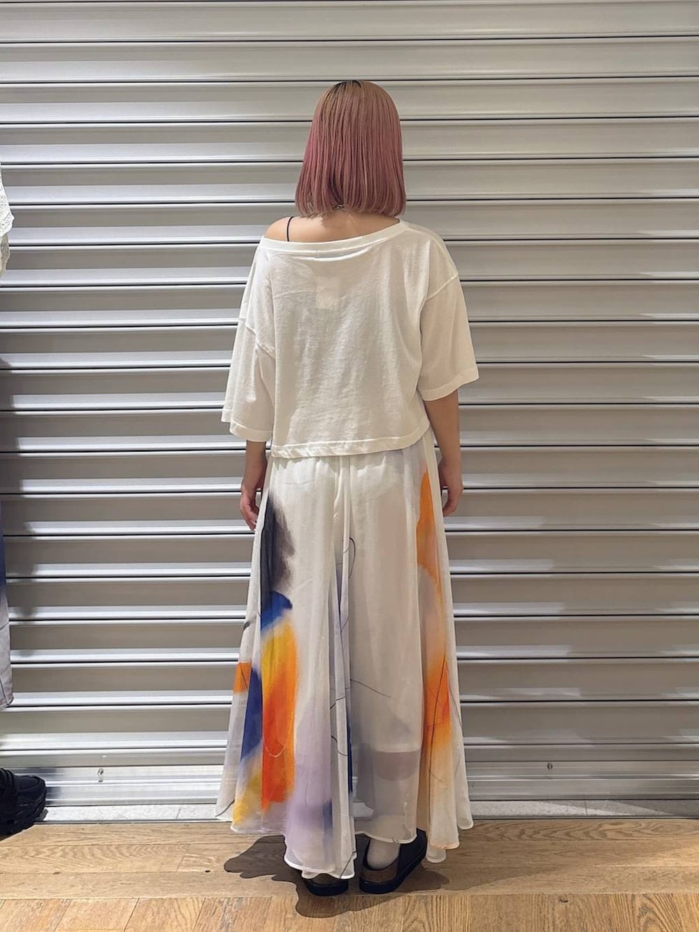 ホワイト系のスカート、ブラック系のローファー、ホワイト系のTシャツ/カットソーを着用したレディースの夏コーディネートの3枚目の写真