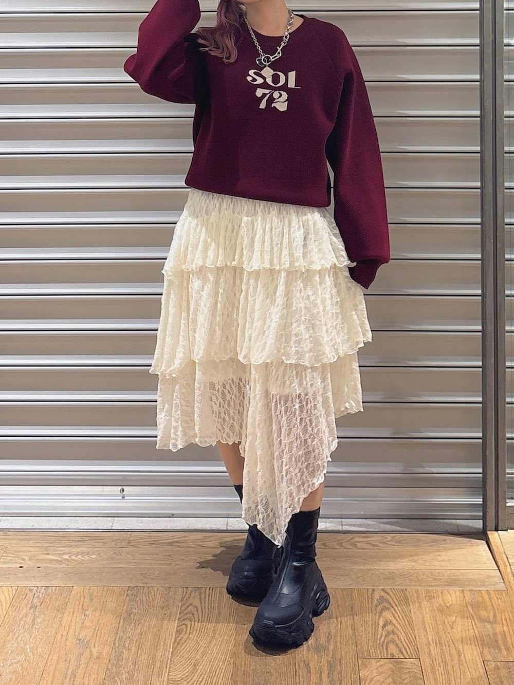 ブラック系のブーツ、ホワイト系のスカート、レッド系のニット/セーターを着用したレディースの秋コーディネートの2枚目の写真