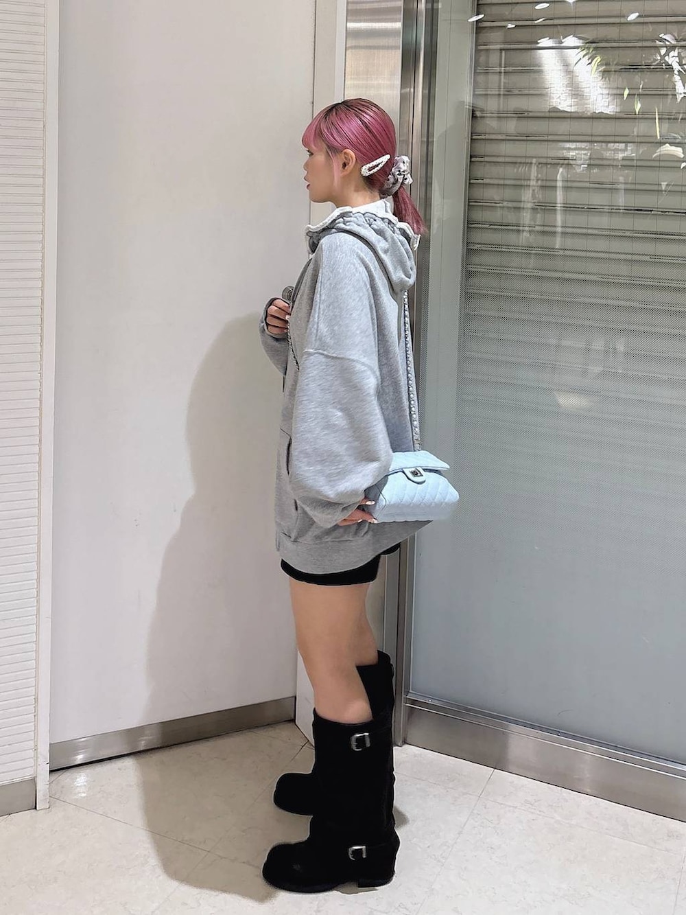 ブラック系のブーツ、グレー系のパーカー、ブラック系のその他パンツを着用したレディースの秋コーディネートの4枚目の写真