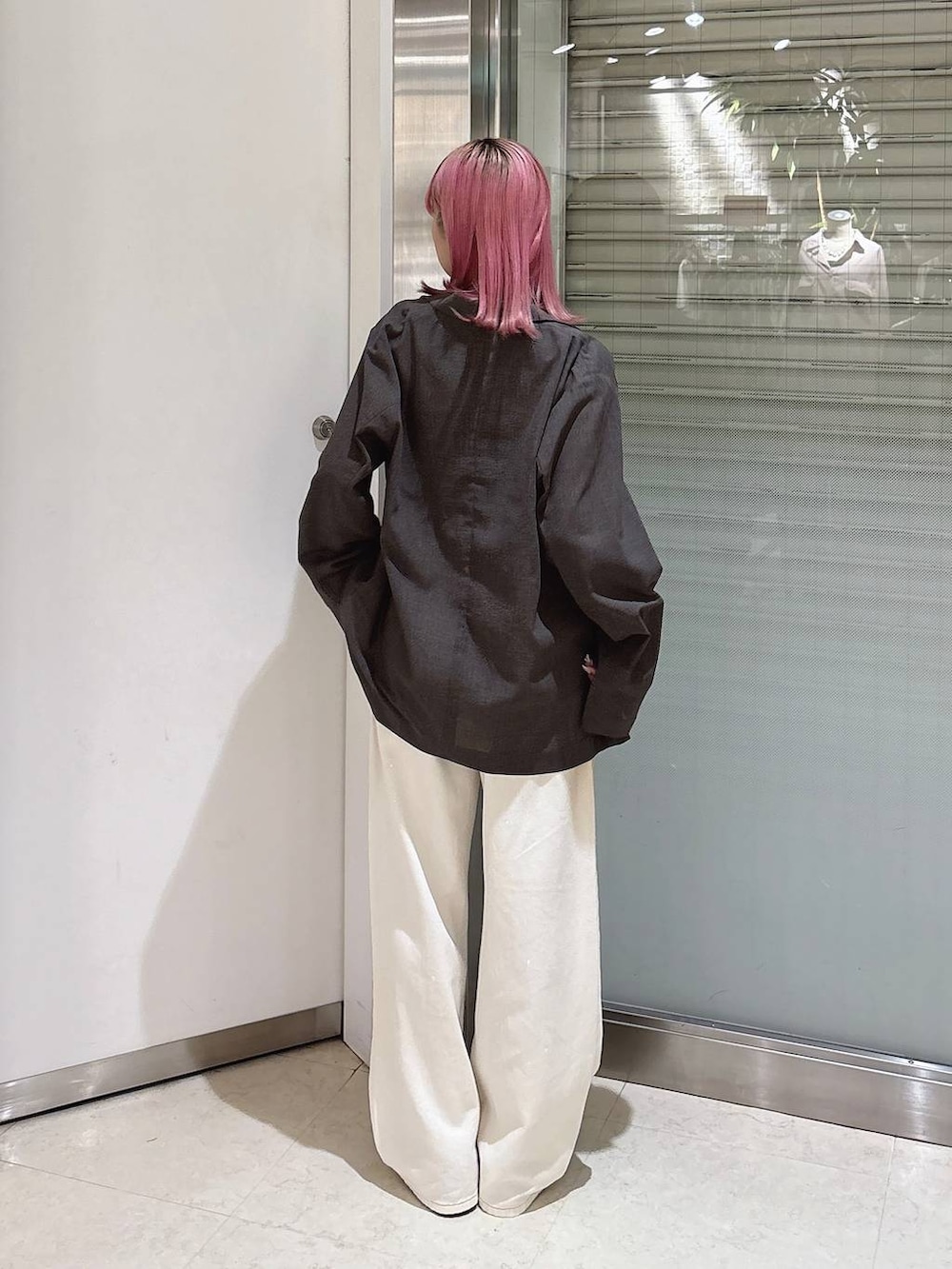 ホワイト系のデニムパンツ、ブラウン系のテーラードジャケット、ブラック系のサンダルを着用したレディースの秋コーディネートの3枚目の写真