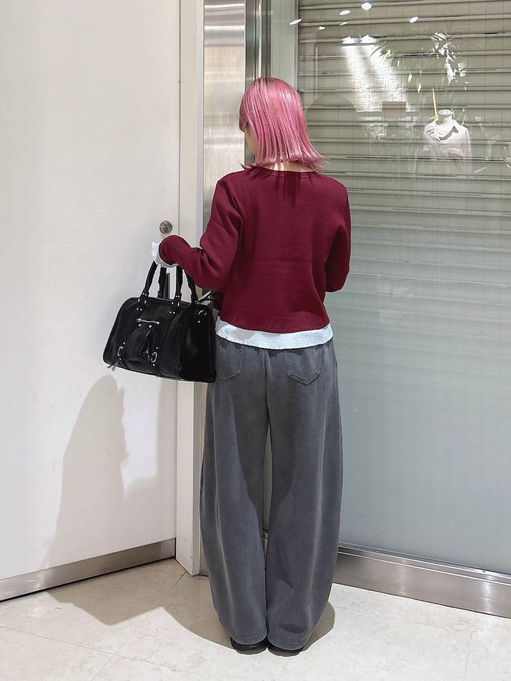 レッド系のカーディガン/ボレロ、ブラック系のローファー、ブラック系のボストンバッグを着用したレディースの秋コーディネートの3枚目の写真