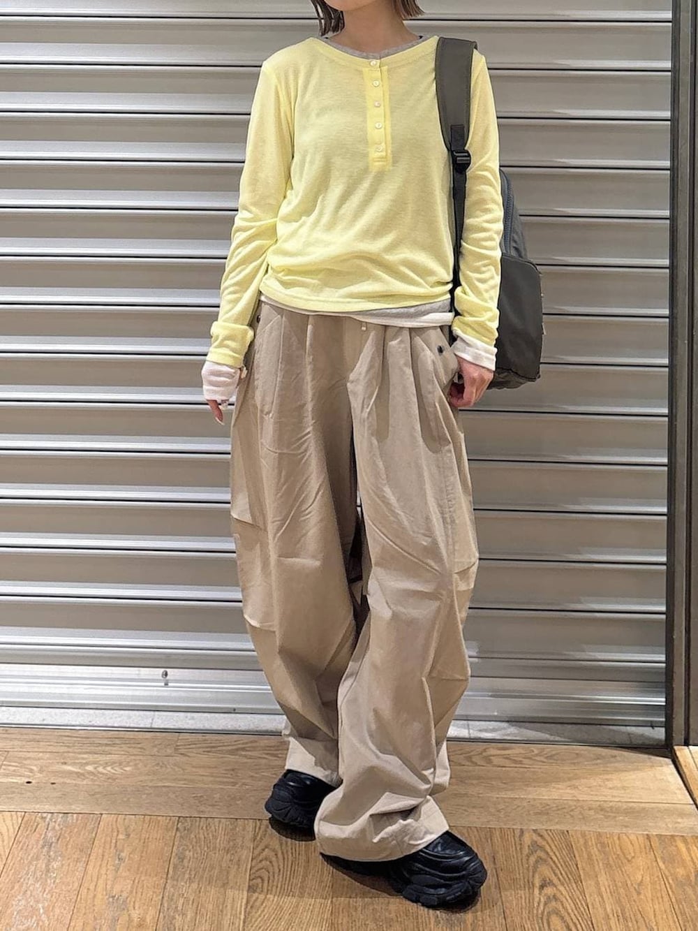 ブラック系のローファー、グリーン系のバックパック/リュック、ベージュ系のその他パンツを着用したレディースの春コーディネートの2枚目の写真