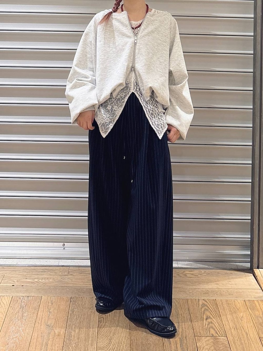 グレー系のスウェット、ブルー系のスラックス、ブラック系のローファーを着用したレディースの春コーディネートの2枚目の写真