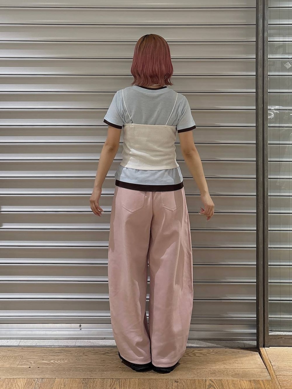 ピンク系のスウェットパンツ、ブラック系のサンダル、ホワイト系のキャミソールを着用したレディースの春コーディネートの3枚目の写真
