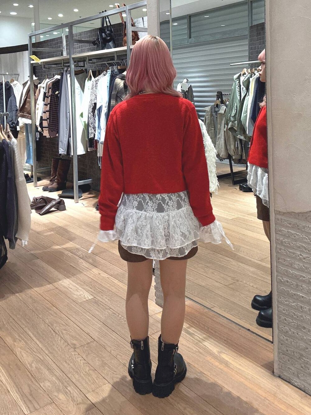 ブラック系のブーツ、レッド系のカーディガン/ボレロ、ホワイト系のシャツ/ブラウスを着用したレディースの冬コーディネートの3枚目の写真