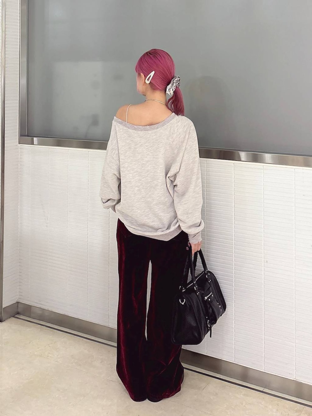 ベージュ系のスウェット、レッド系のデニムパンツ、ブラック系のボストンバッグを着用したレディースの秋コーディネートの4枚目の写真