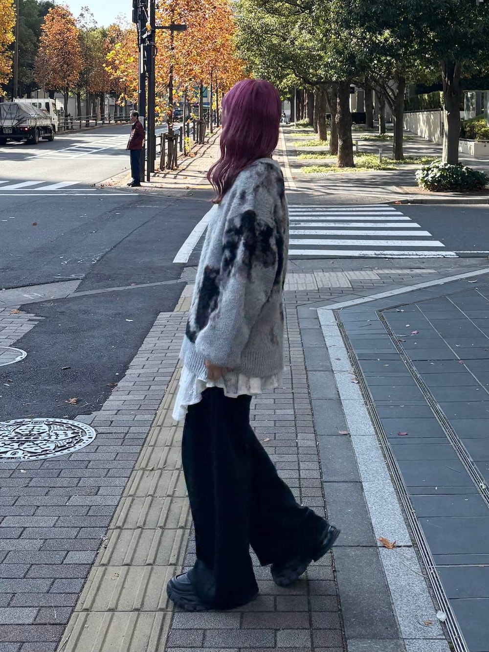 グレー系のニット/セーター、ブラック系のローファー、ホワイト系のワンピースを着用したレディースの秋コーディネートの3枚目の写真