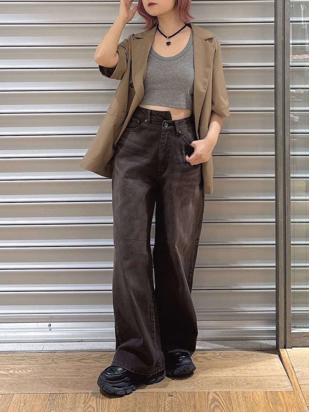 グレー系のタンクトップ、ブラック系のローファー、ブラウン系のデニムパンツを着用したレディースの春コーディネートの2枚目の写真