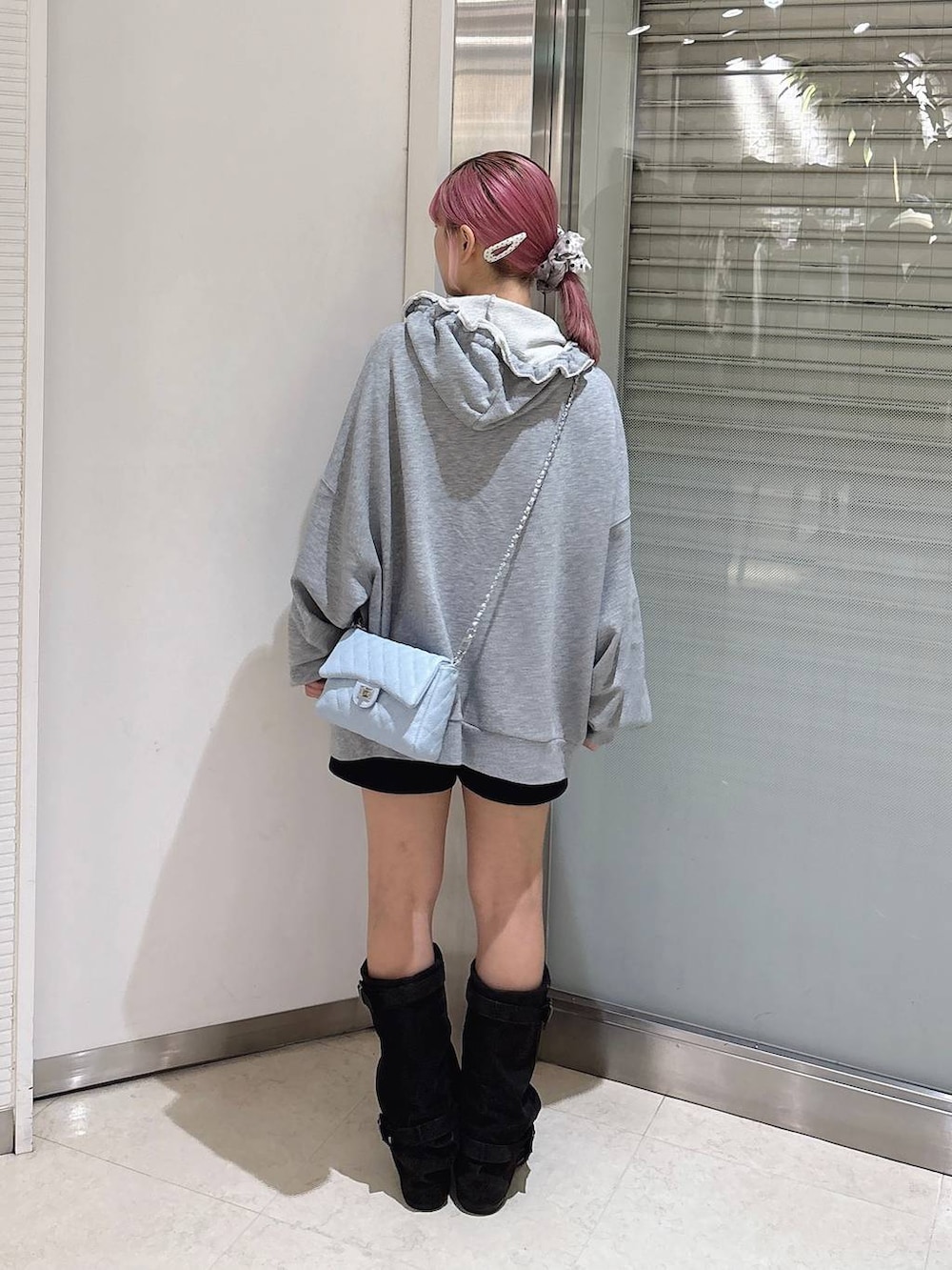 ブラック系のブーツ、グレー系のパーカー、ブラック系のその他パンツを着用したレディースの秋コーディネートの3枚目の写真