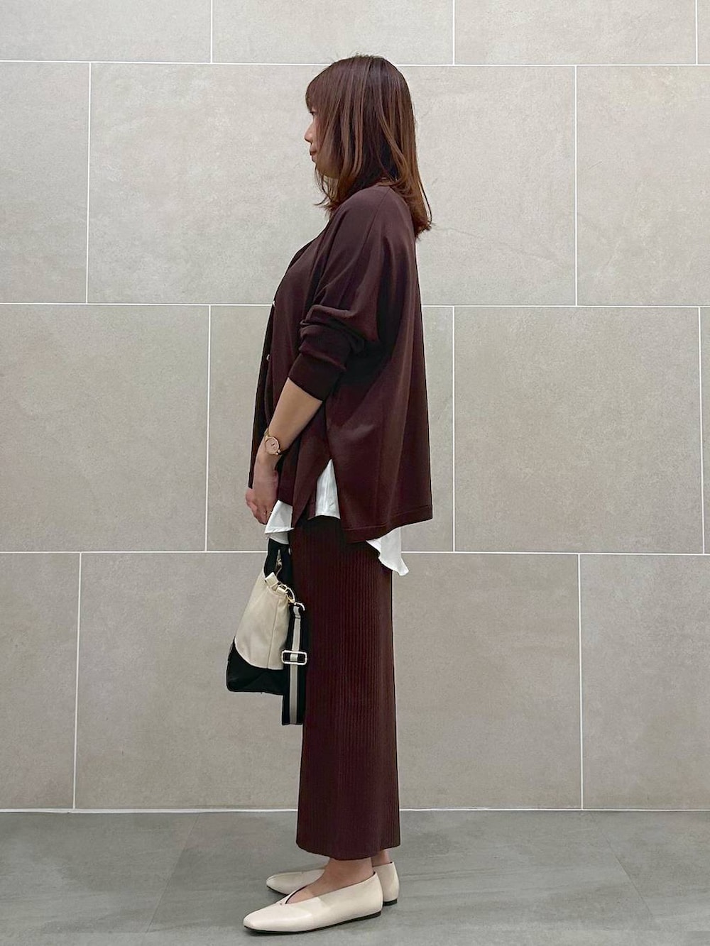 ホワイト系のパンプス、ブラウン系のスカート、ベージュ系のショルダーバッグを着用したレディースの春コーディネートの3枚目の写真