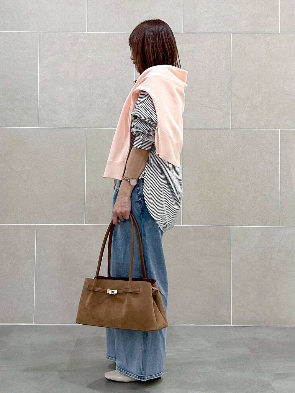 ホワイト系のパンプス、ブルー系のデニムパンツ、イエロー系のハンドバッグを着用したレディースの春コーディネートの3枚目の写真