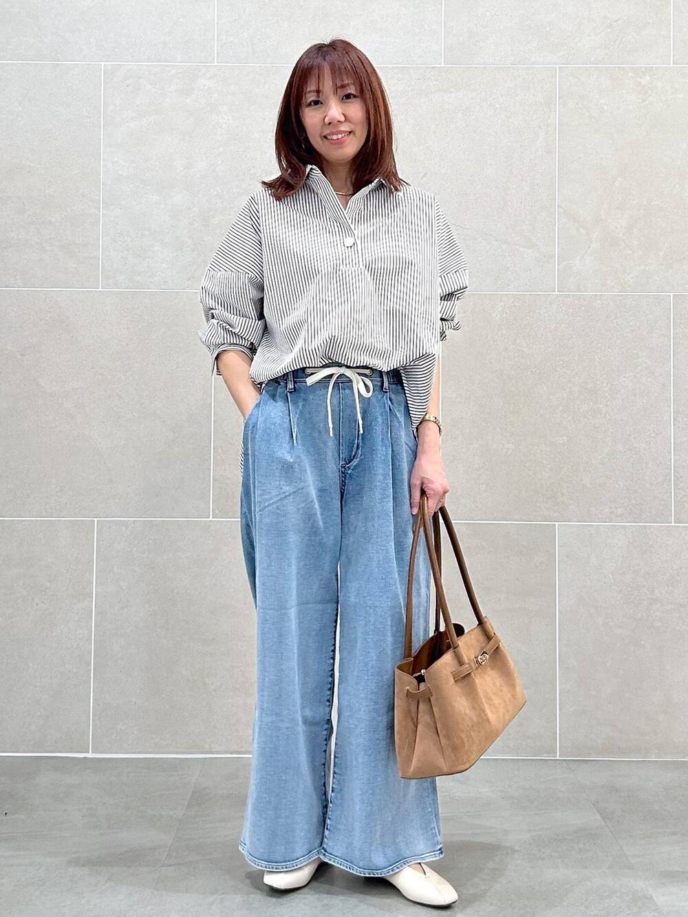 ホワイト系のパンプス、ブルー系のデニムパンツ、イエロー系のハンドバッグを着用したレディースの春コーディネートの8枚目の写真