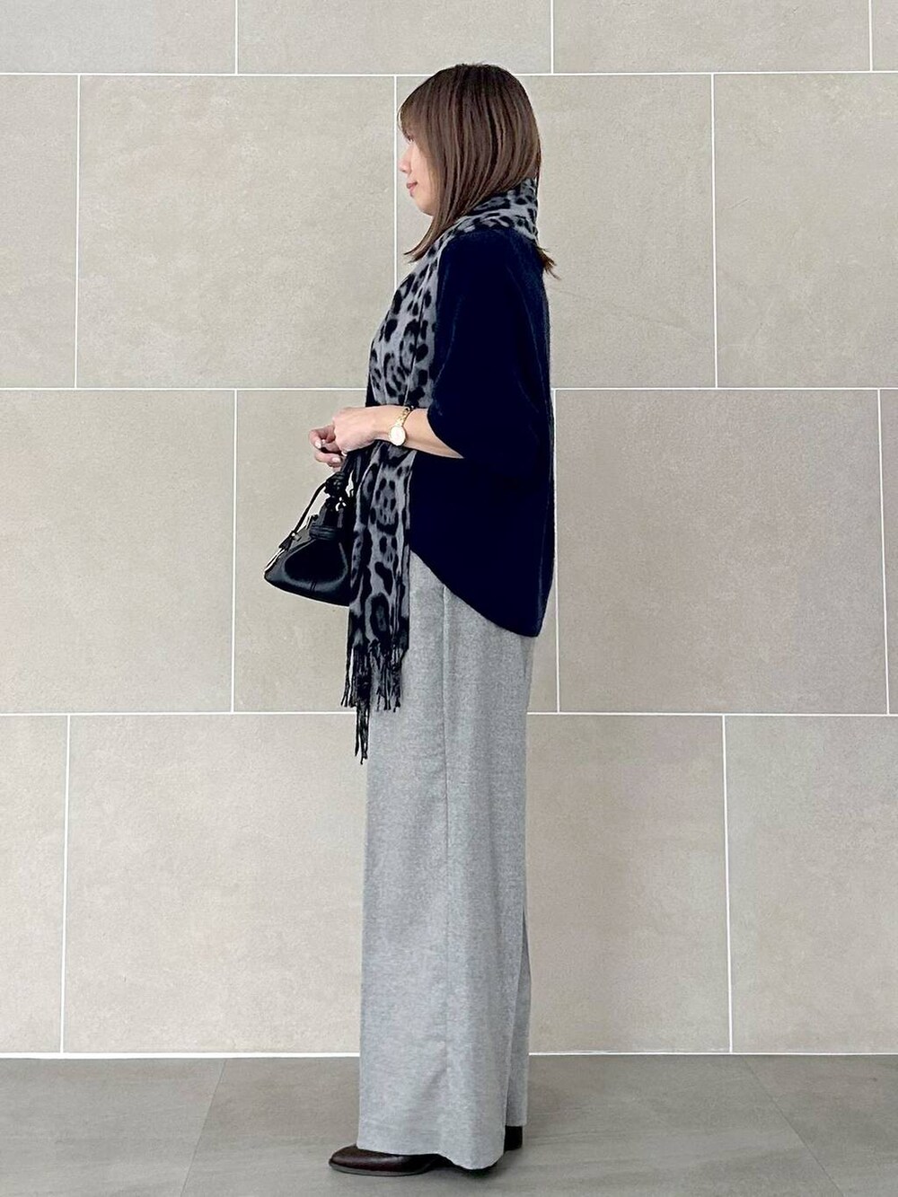 ブルー系のニット/セーター、グレー系のその他パンツ、ブラック系のストール/ショールを着用したレディースの秋コーディネートの4枚目の写真