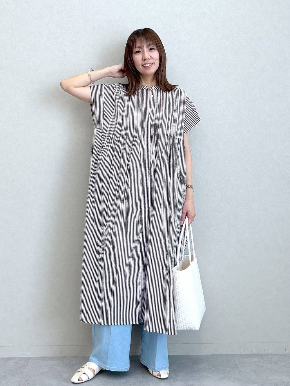 ブラウン系のワンピース、ホワイト系のパンプス、ホワイト系のかごバッグを着用したレディースの夏コーディネートの6枚目の写真
