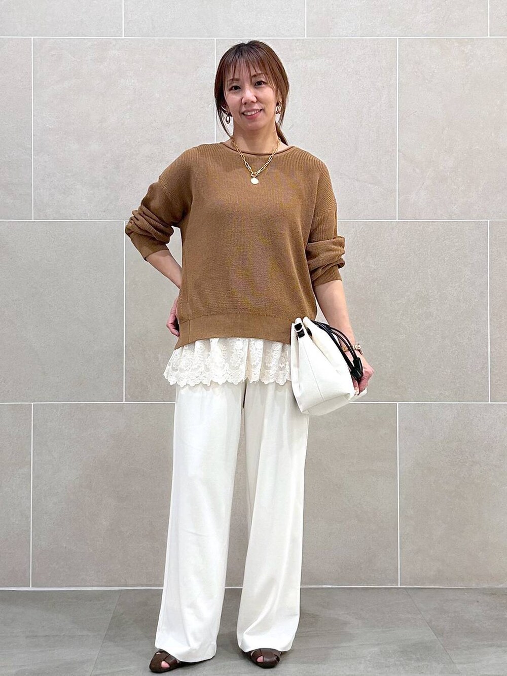 ホワイト系のその他パンツ、イエロー系のニット/セーター、ホワイト系のタンクトップを着用したレディースの春コーディネートの5枚目の写真