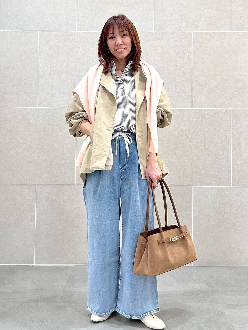 ホワイト系のパンプス、ブルー系のデニムパンツ、イエロー系のハンドバッグを着用したレディースの春コーディネートの2枚目の写真