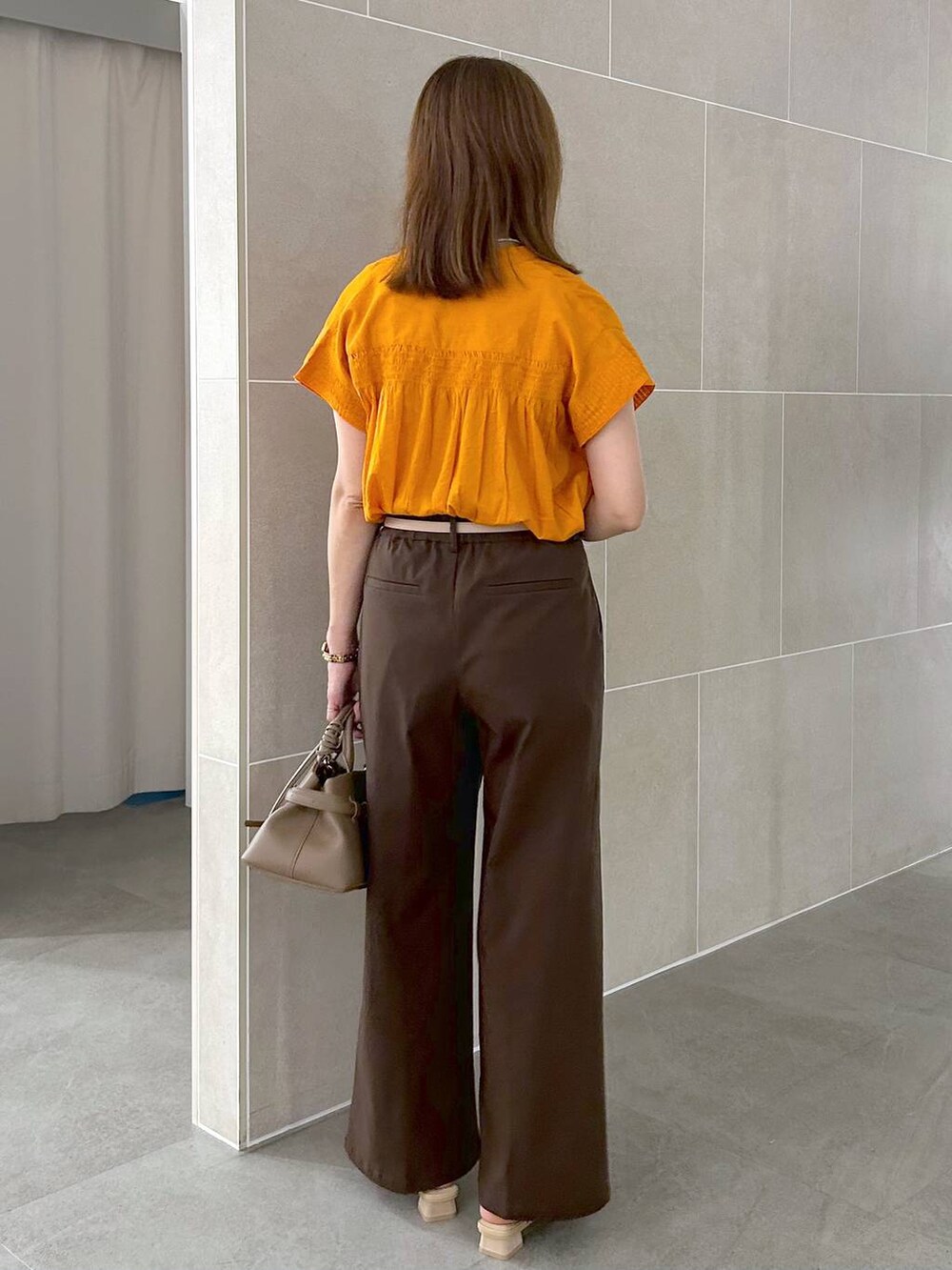 オレンジ系のシャツ/ブラウス、ブラウン系のその他パンツ、ベージュ系のサンダルを着用したレディースの夏コーディネートの4枚目の写真