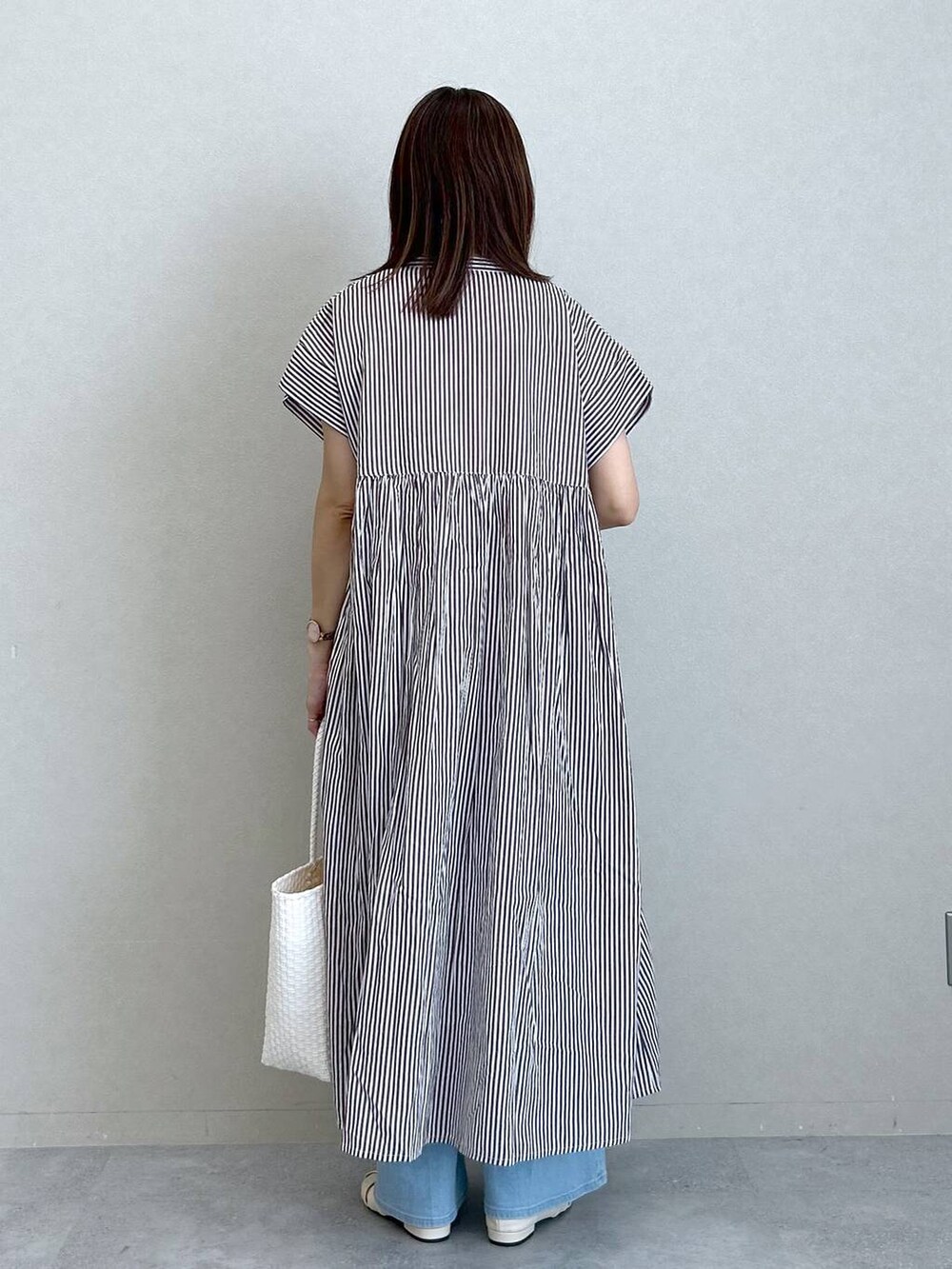 ブラウン系のワンピース、ホワイト系のパンプス、ホワイト系のかごバッグを着用したレディースの夏コーディネートの4枚目の写真