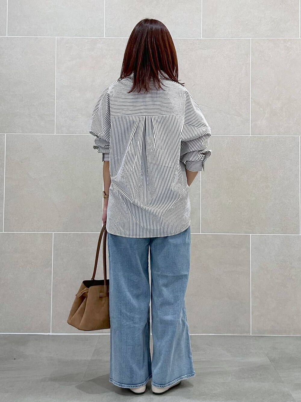 ホワイト系のパンプス、ブルー系のデニムパンツ、イエロー系のハンドバッグを着用したレディースの春コーディネートの5枚目の写真