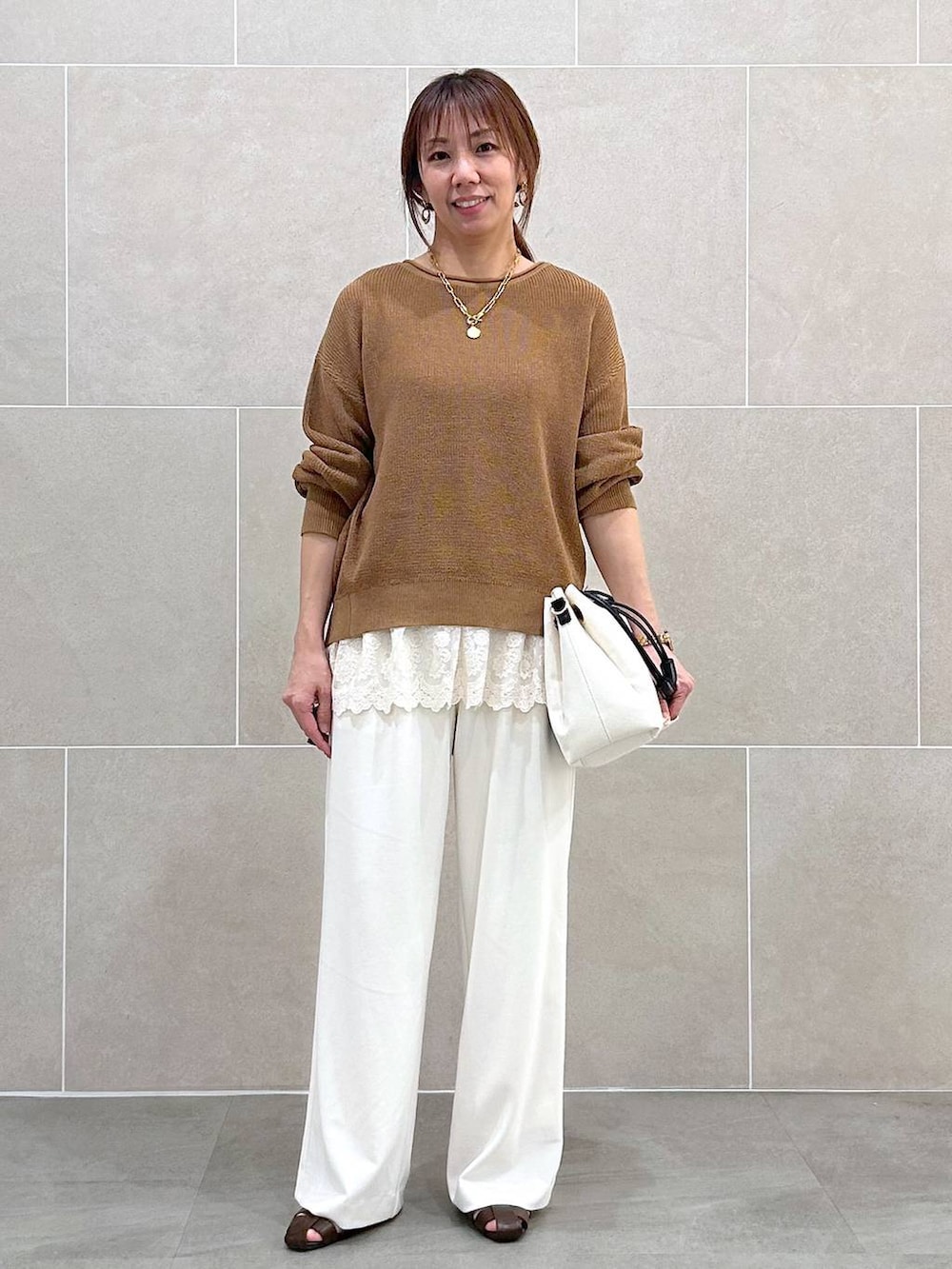 ホワイト系のその他パンツ、イエロー系のニット/セーター、ホワイト系のタンクトップを着用したレディースの春コーディネートの2枚目の写真