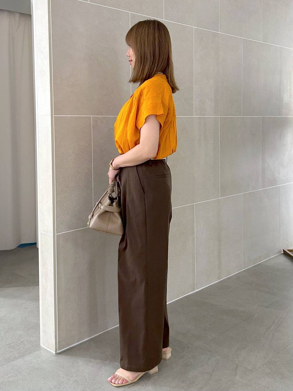 オレンジ系のシャツ/ブラウス、ブラウン系のその他パンツ、ベージュ系のサンダルを着用したレディースの夏コーディネートの3枚目の写真