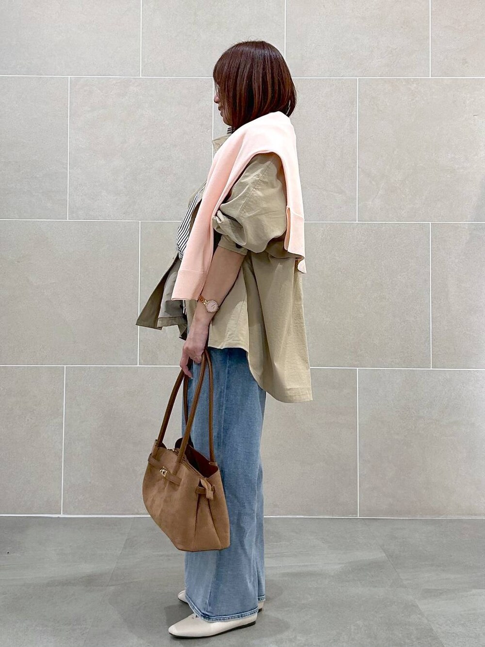 ホワイト系のパンプス、ブルー系のデニムパンツ、イエロー系のハンドバッグを着用したレディースの春コーディネートの3枚目の写真