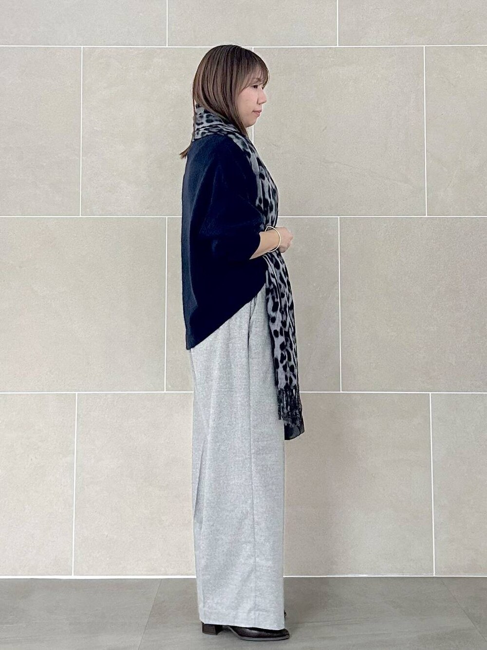 ブルー系のニット/セーター、グレー系のその他パンツ、ブラック系のストール/ショールを着用したレディースの秋コーディネートの6枚目の写真