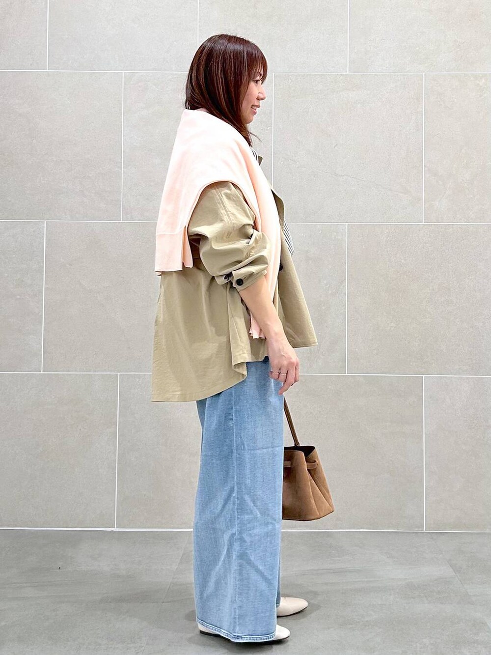 ホワイト系のパンプス、ブルー系のデニムパンツ、イエロー系のハンドバッグを着用したレディースの春コーディネートの5枚目の写真