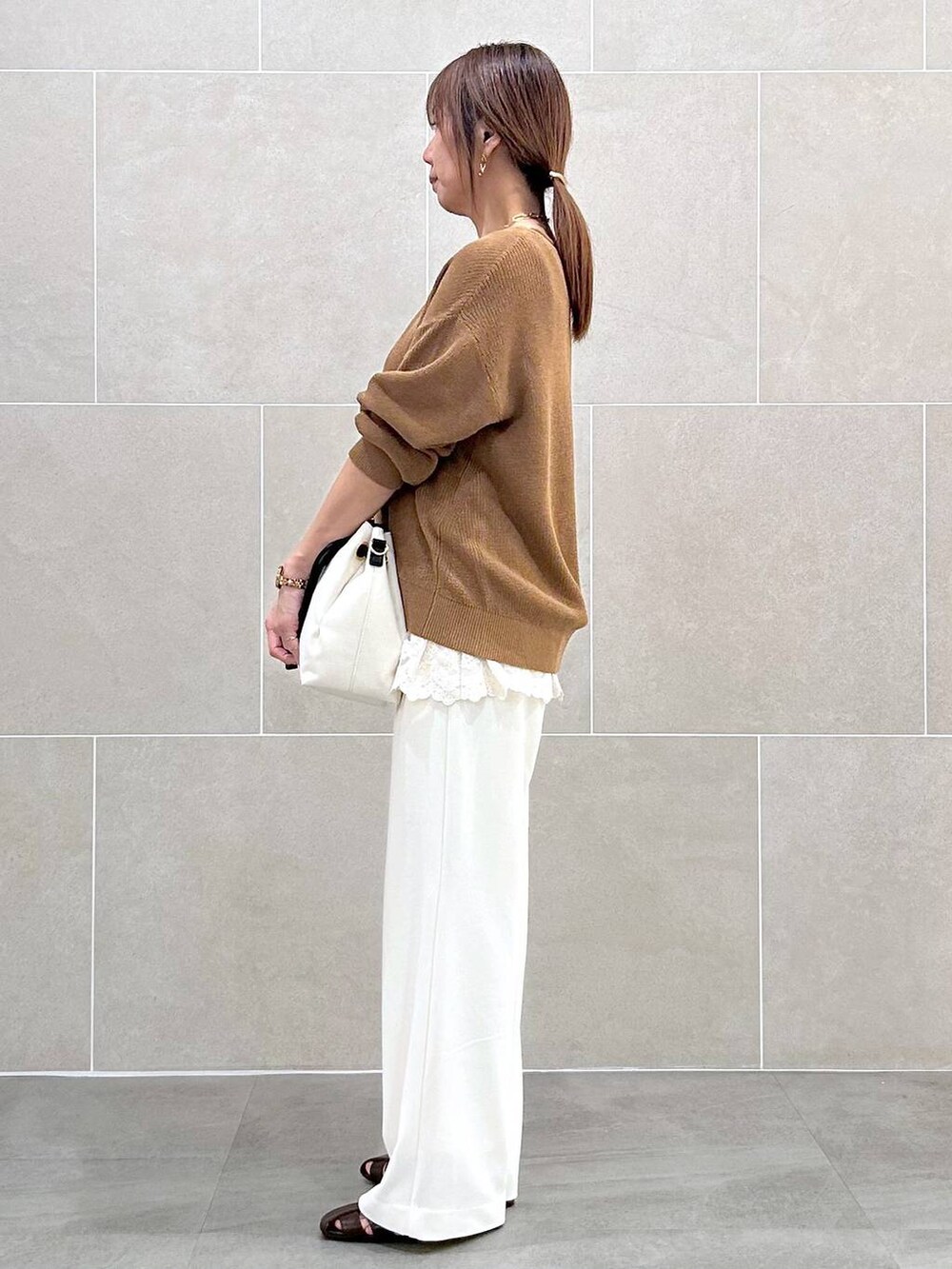 ホワイト系のその他パンツ、イエロー系のニット/セーター、ホワイト系のタンクトップを着用したレディースの春コーディネートの3枚目の写真