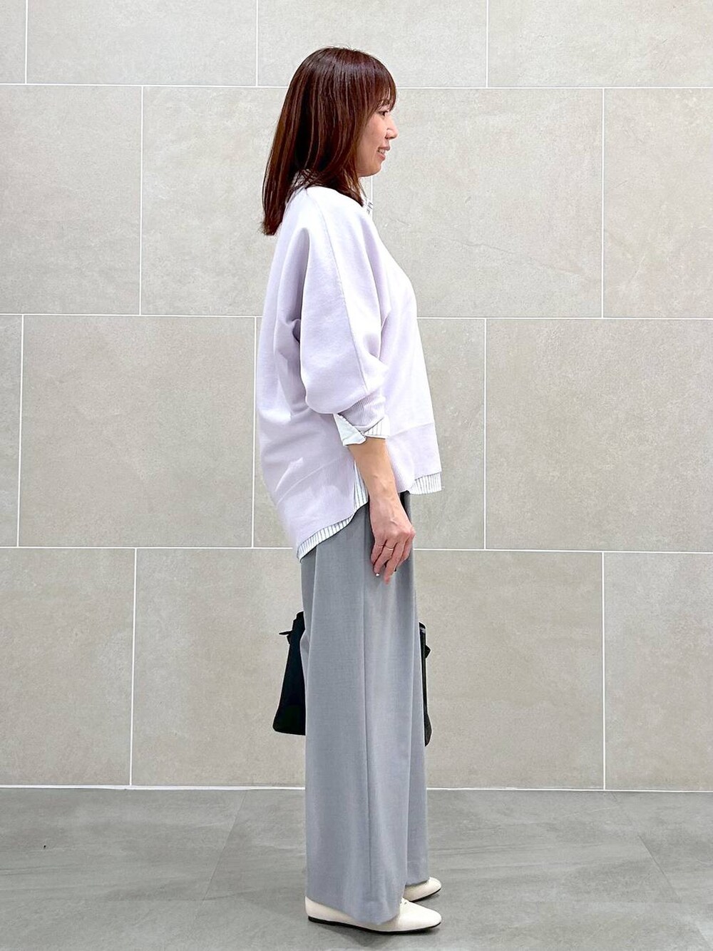 ホワイト系のパンプス、ブラック系のハンドバッグ、ホワイト系のシャツ/ブラウスを着用したレディースの春コーディネートの5枚目の写真