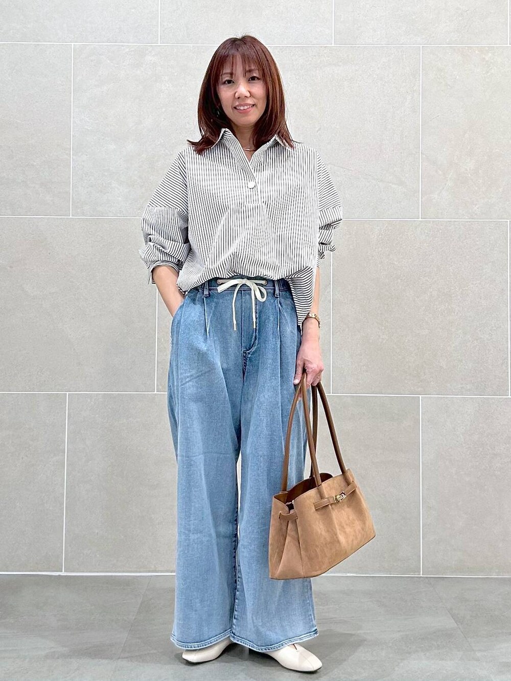 ホワイト系のパンプス、ブルー系のデニムパンツ、イエロー系のハンドバッグを着用したレディースの春コーディネートの7枚目の写真