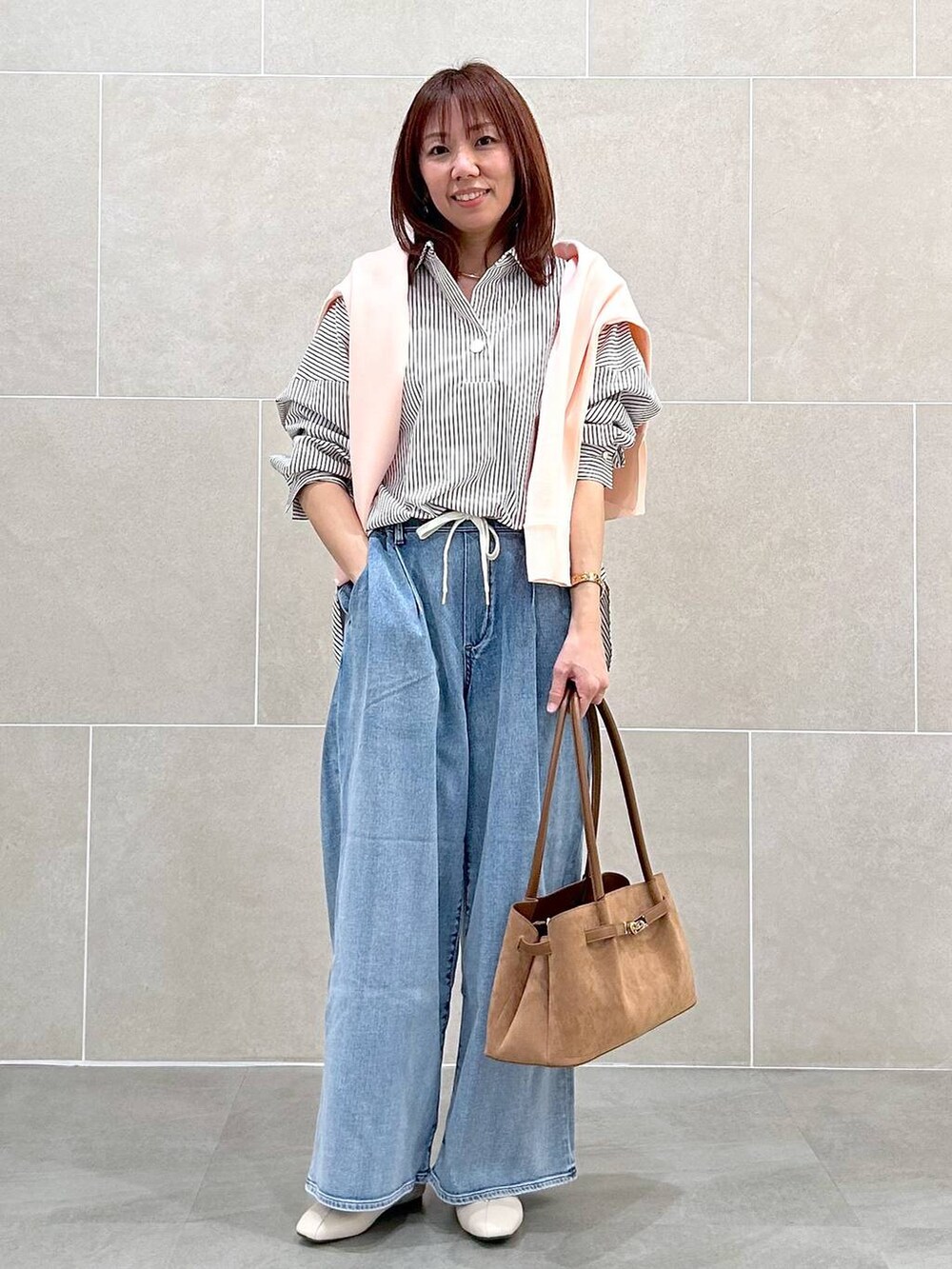 ホワイト系のパンプス、ブルー系のデニムパンツ、イエロー系のハンドバッグを着用したレディースの春コーディネートの9枚目の写真