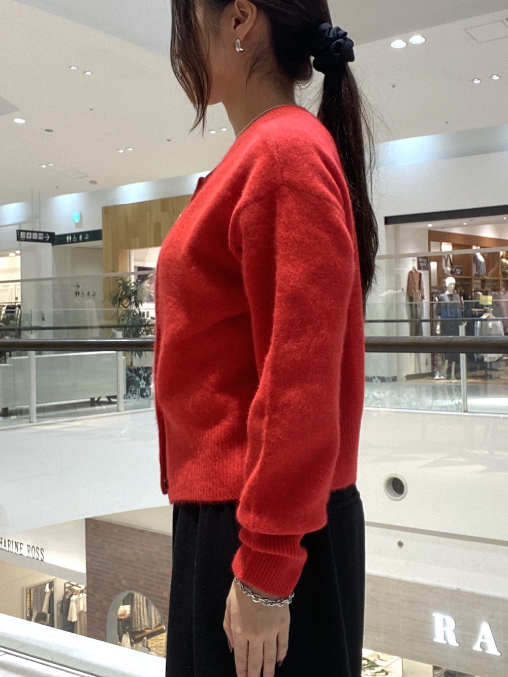 レッド系のカーディガン/ボレロ、ブラック系のスラックス、ブラック系のボストンバッグを着用したレディースの秋コーディネートの5枚目の写真