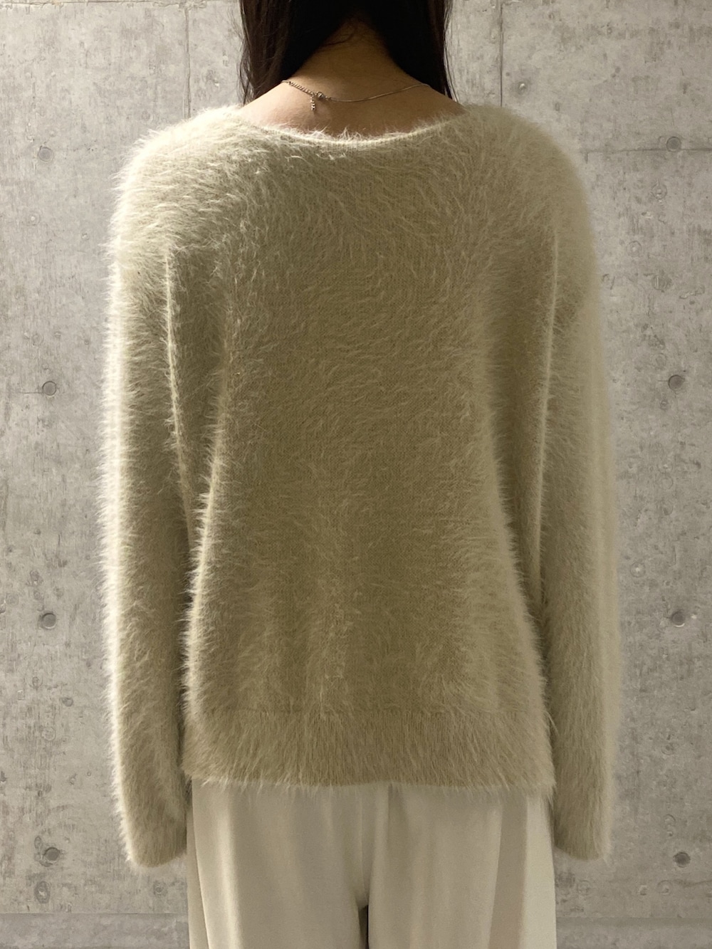 ホワイト系のニット/セーター、ホワイト系のスラックス、ベージュ系のその他シューズを着用したレディースの冬コーディネートの6枚目の写真