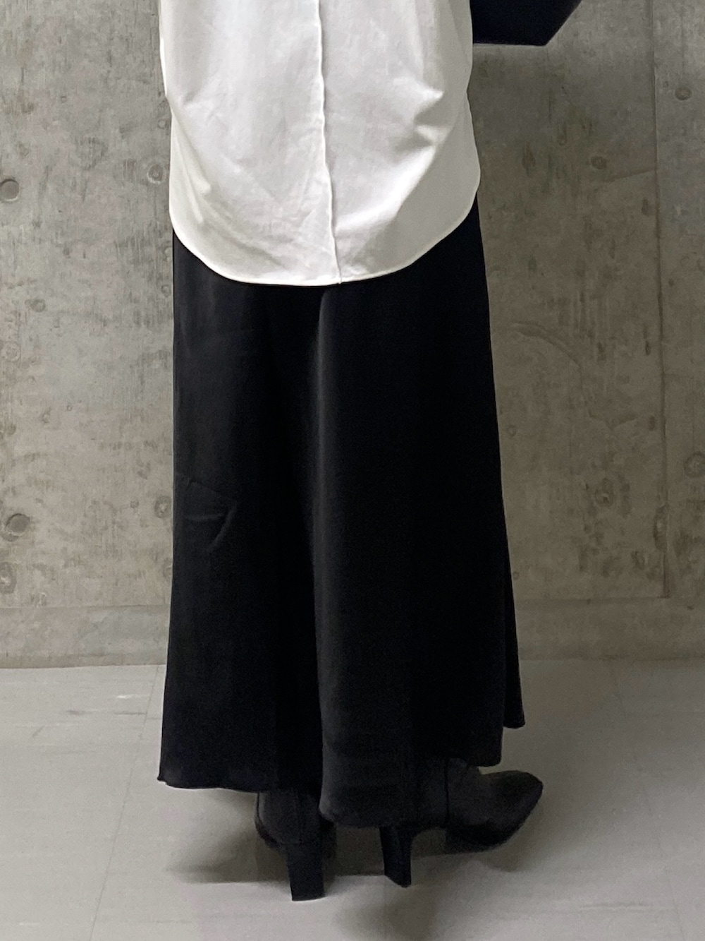 ブラック系のスカート、ホワイト系のTシャツ/カットソー、ブラック系のハンドバッグを着用したレディースの秋コーディネートの9枚目の写真