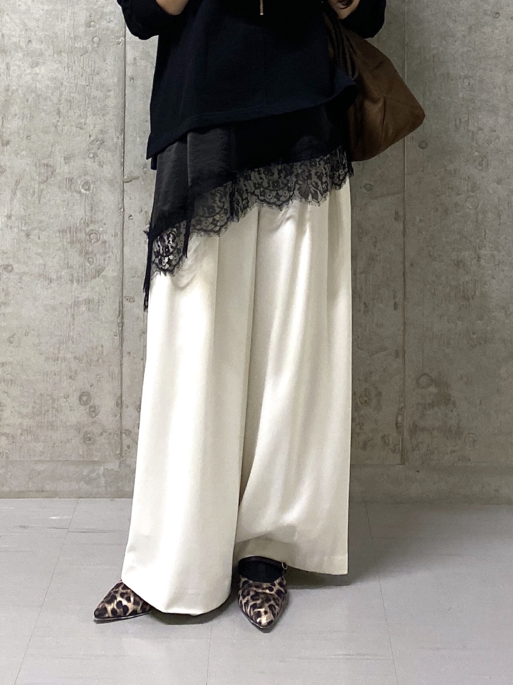 ホワイト系のスラックス、ブラック系のキャミソール、ブラック系のスウェットを着用したレディースの春コーディネートの4枚目の写真