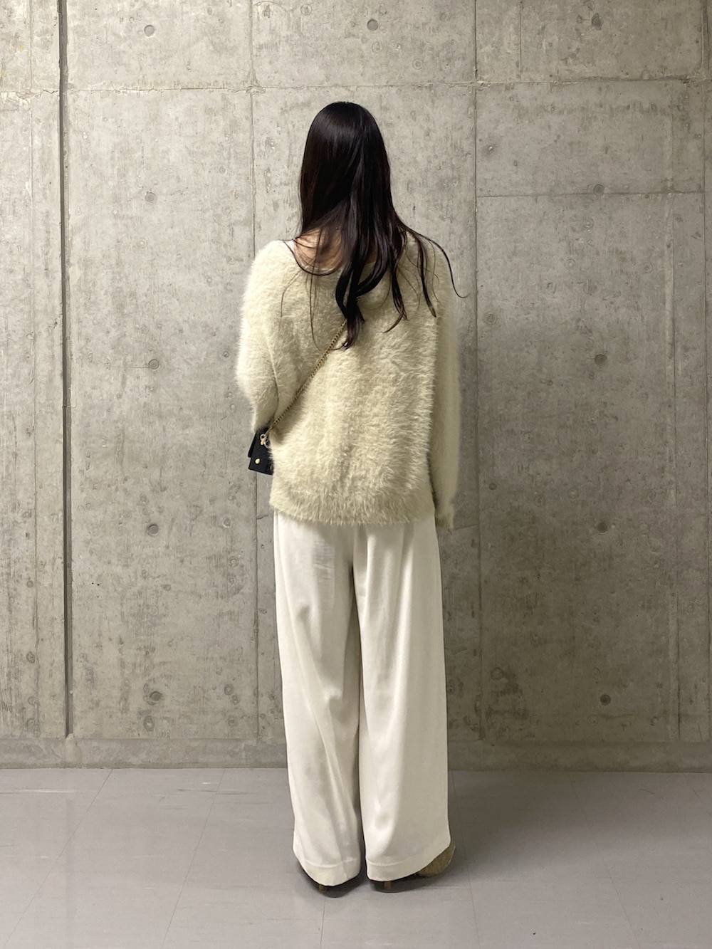 ホワイト系のニット/セーター、ホワイト系のスラックス、ベージュ系のその他シューズを着用したレディースの冬コーディネートの3枚目の写真