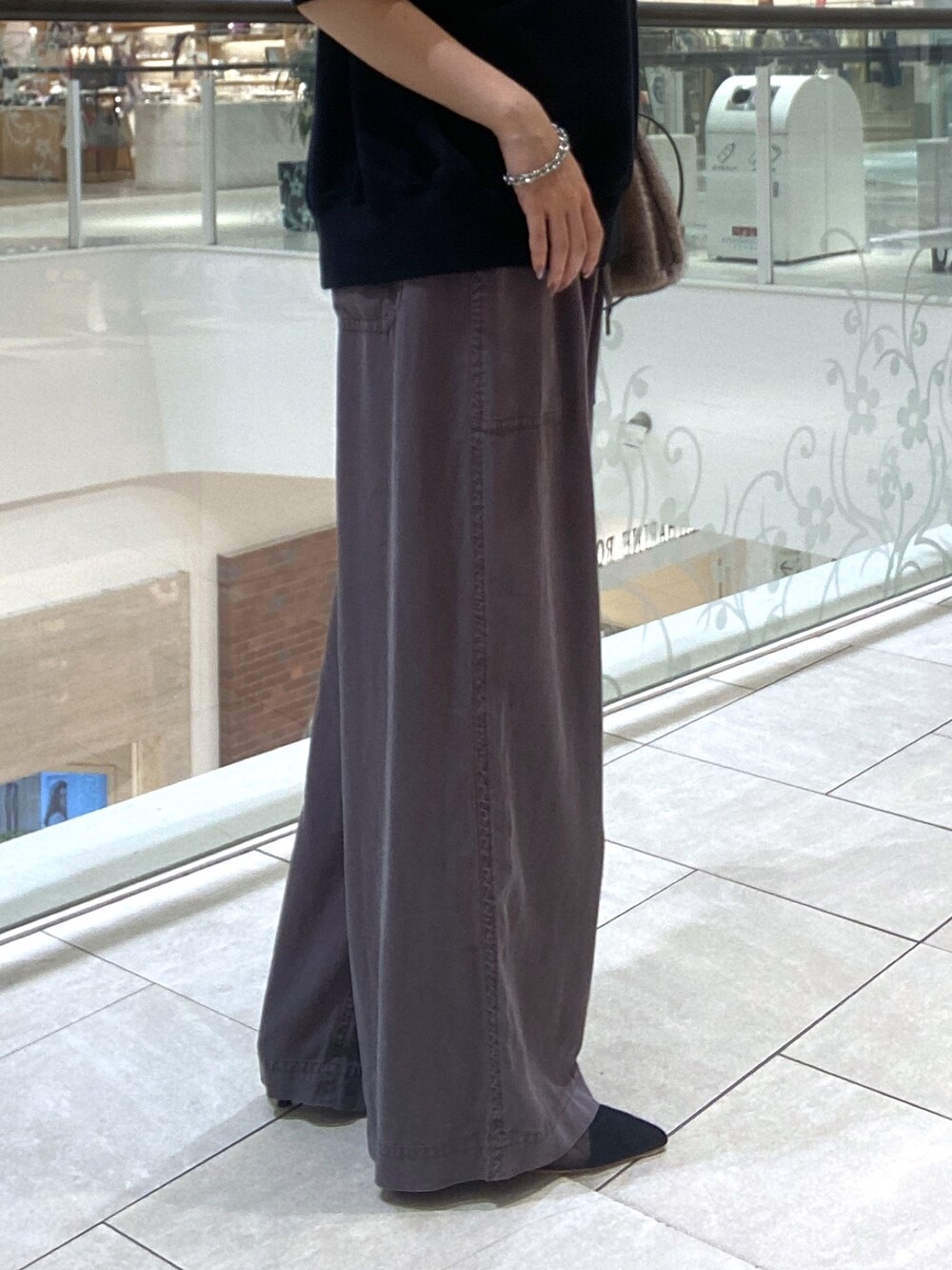 ブラック系のスウェット、グレー系のその他パンツ、ブラウン系のハンドバッグを着用したレディースの夏コーディネートの8枚目の写真