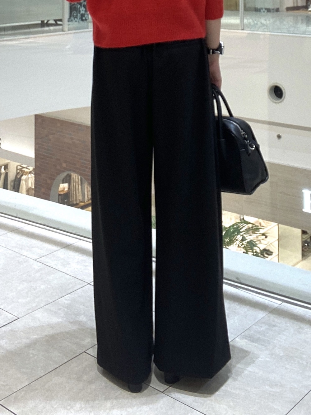 レッド系のカーディガン/ボレロ、ブラック系のスラックス、ブラック系のボストンバッグを着用したレディースの秋コーディネートの9枚目の写真