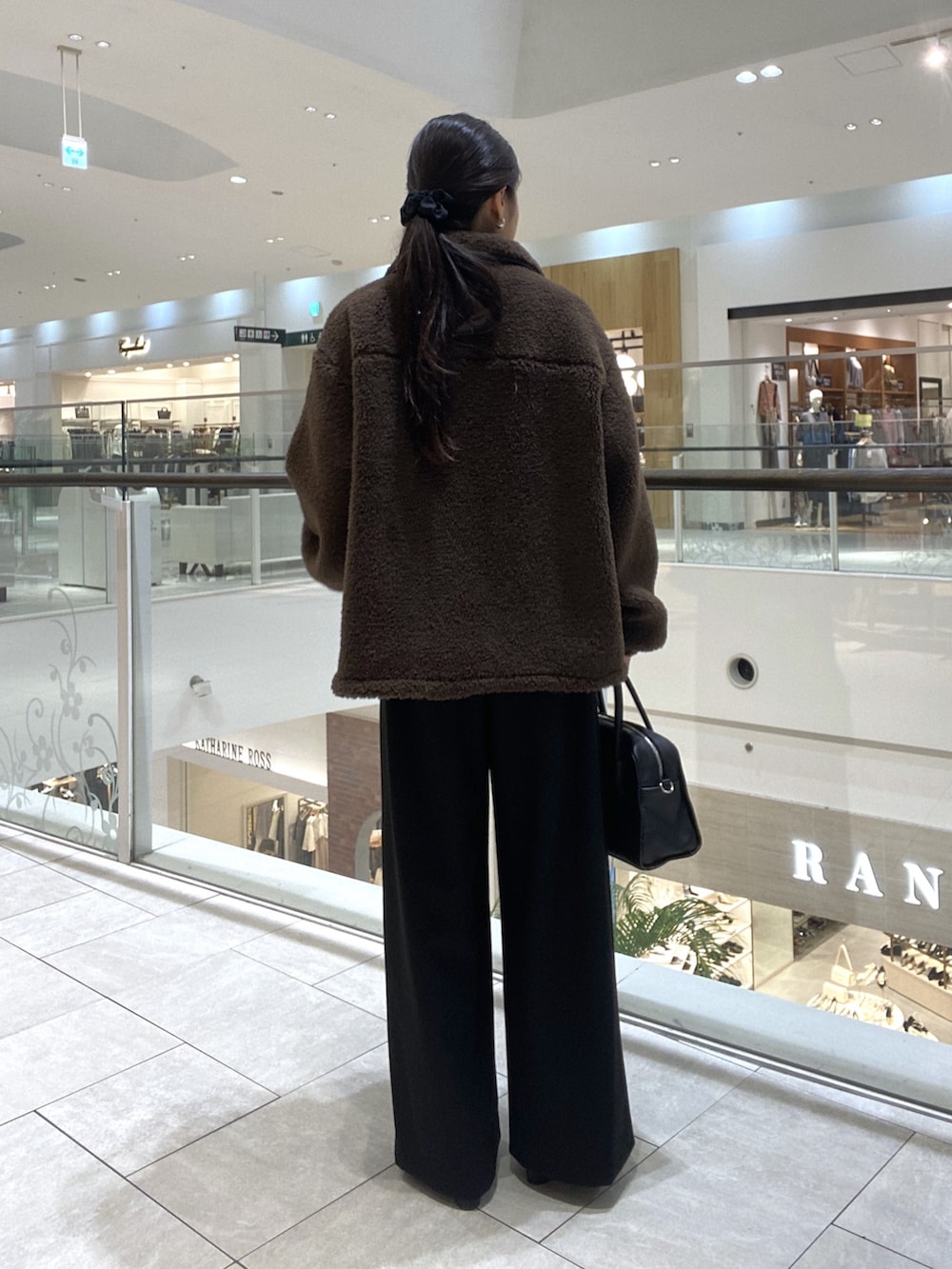 ブラウン系のその他アウター、ブラック系のスラックス、ブラック系のブーツを着用したレディースの秋コーディネートの3枚目の写真