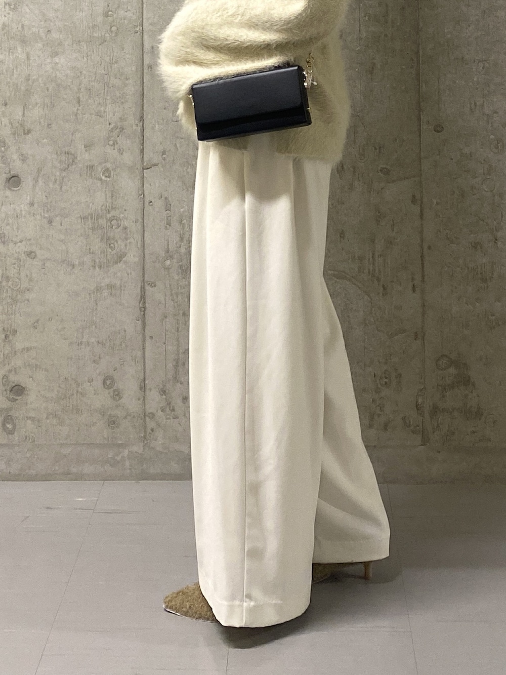 ホワイト系のニット/セーター、ホワイト系のスラックス、ベージュ系のその他シューズを着用したレディースの冬コーディネートの8枚目の写真