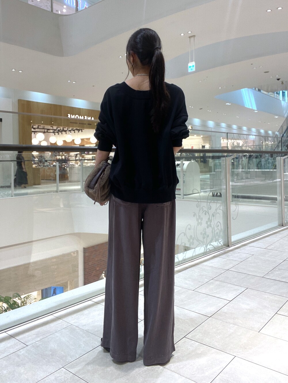 ブラック系のスウェット、グレー系のその他パンツ、ブラウン系のハンドバッグを着用したレディースの夏コーディネートの3枚目の写真